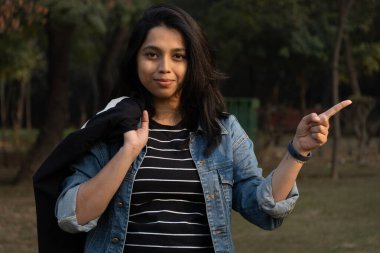 Kafasını kullanarak bir şey gösteren bir üniversite öğrencisi.