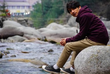 Nehir kenarında oturan adam