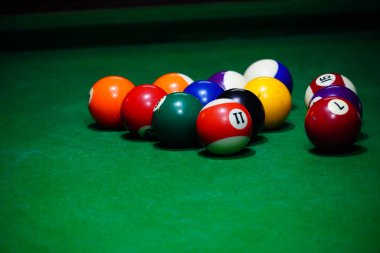 Kulüp binasında bir bilardo masası ve top.