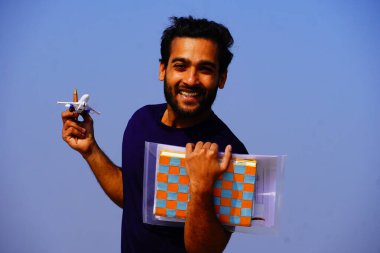 Sırt çantası ve kitaplarla gülümseyen genç üniversite öğrencisinin portresi.