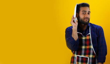 Yemeği olmayan üzgün bir adam. Mutfakta önlüklü yemek yapacak.