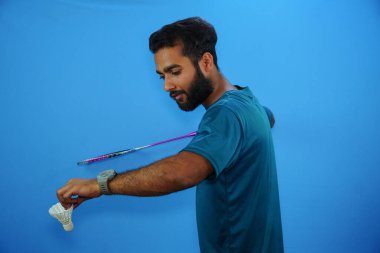 Badminton oynayan adam mavi arka planda izole edilmiş.