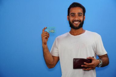 Hintli adam mavi izole bir arka planda metro kartı gösteriyor.