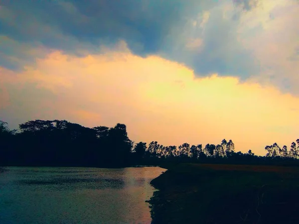 湖の風景 ほとんど夜だ 空の雲と太陽の光が湖に落ちる — ストック写真
