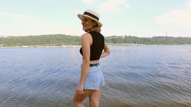 Young Woman Short Denim Shorts Hat Walks Beach River Slow — Vídeo de Stock