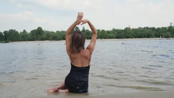 Sahilin Yanındaki Suyun Üzerinde Siyah Elbiseli Bir Kadının Dikiz Görüntüsü — Stok video