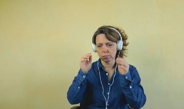 Сорокарічна Жінка Джинсовій Сорочці Слухає Музику Великих Дротових Білих Навушниках Ліцензійні Стокові Фото