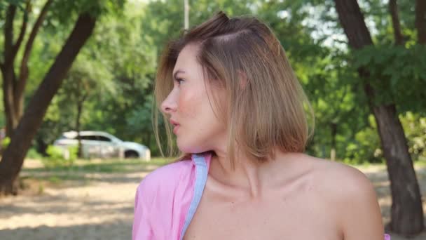 Egy Fiatal Portréja Rózsaszín Ingben Sötét Fák Közelében Lassú Mozgás — Stock videók
