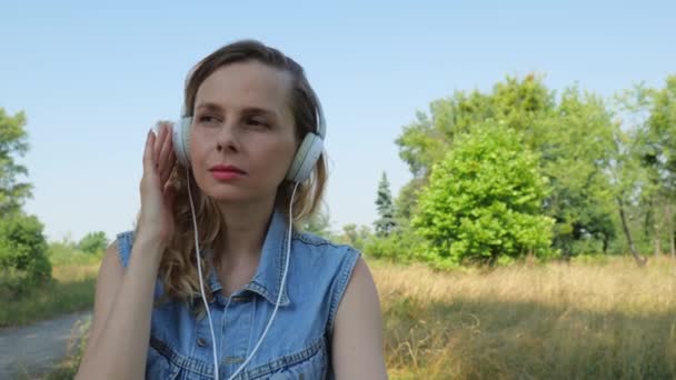 Portrét Mladé Blondýny Džínové Bundě Poslouchá Hudbu Velkých Drátových Sluchátkách — Stock video