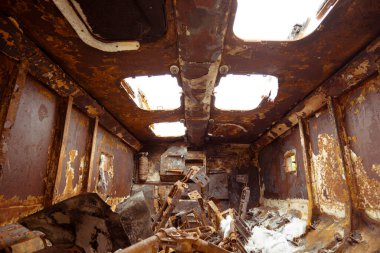 Yanmış bir askeri aracın içeriden görünüşü. Bir sürü paslı metal. Yanmış araba.