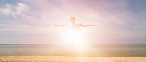 Airplane and bright sun over the sea and beach. Journey to a warm country. Tourism and recreation in summer. bright white sun