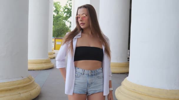 Young Woman Denim Shorts White Shirt Walks White Columns Talking — 비디오