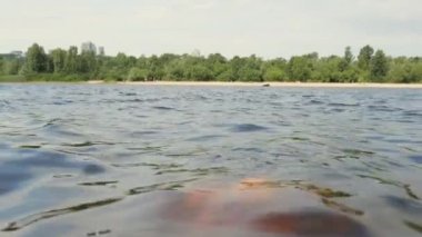Young blonde woman in a pink swimsuit in the water in nature. Wet woman. woman swimming