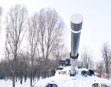 Bottom view of a tank cannon in the winter in the snow. Tank in the winter forest. War in winter