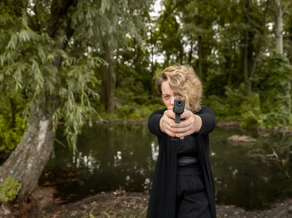 Жінка Темному Одязі Стоїть Лісі Біля Болотних Пагонів Пістолетом Портрет — стокове фото