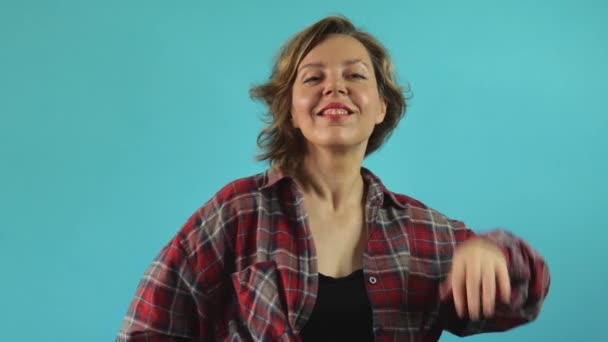 Взрослая Женщина Клетчатой Рубашке Выпрямляет Волосы Изолированном Синем Фоне Портрет — стоковое видео