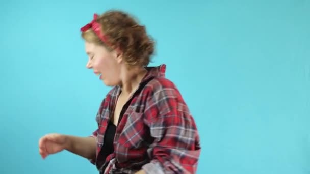 Pin Γυναίκα Ένα Καρό Πουκάμισο Φτερνίζεται Ένα Απομονωμένο Μπλε Φόντο — Αρχείο Βίντεο