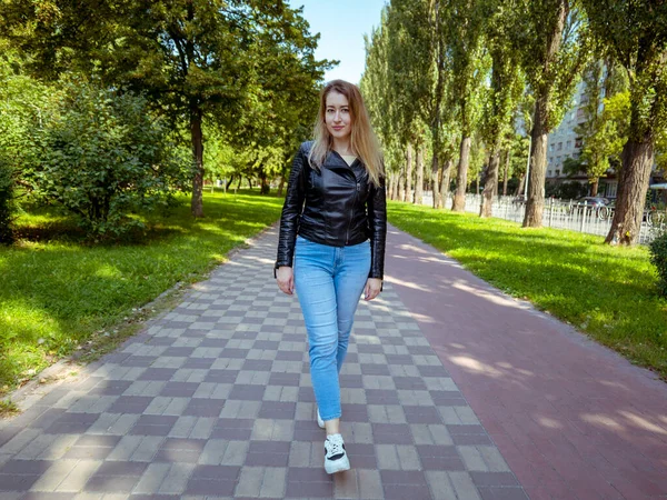 Young Woman Leather Jacket Denim Pants Walks Road City Park — Stok fotoğraf