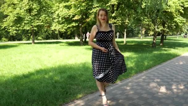드레스를 점들이 여자가 공원의 도로에서 여자의 — 비디오