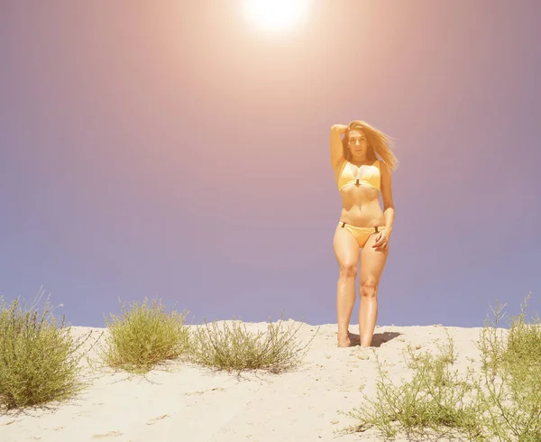 砂漠を見下ろすの砂の上に立って黄色の水着の女性の下のビュー 水着女性 リラックスした女性 夏は暑い — ストック写真