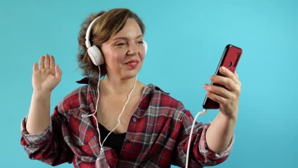 Una Mujer Adulta Escucha Música Auriculares Grandes Sostiene Teléfono Móvil — Vídeos de Stock