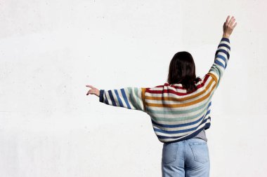 Beyaz arka planda renkli kazaklı bir kız.