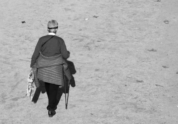 Mujer mayor caminando sobre una muleta —  Fotos de Stock