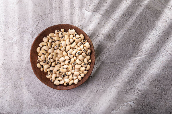 pile of black-eyed beans, in container on concrete surface- lubiya