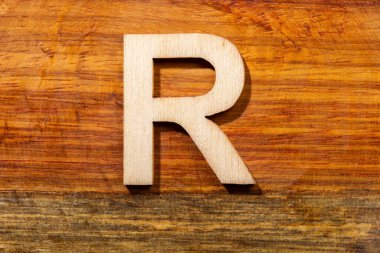 Wooden letters R on wooden background, top view