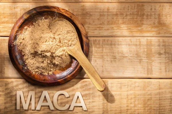 Maca Powder Wooden Bowl Table Nutritional Substance Peru lizenzfreie Stockfotos