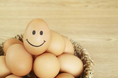 Tahta masanın üzerinde gülümseyen tavuk yumurtaları..