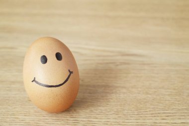 Tahta masada gülümseyen tavuk yumurtaları..