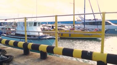 Limanda park etmiş yatlar, metal bir çitin arkasını görüyor.