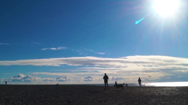 Una playa rocosa, gente caminando — Vídeos de Stock