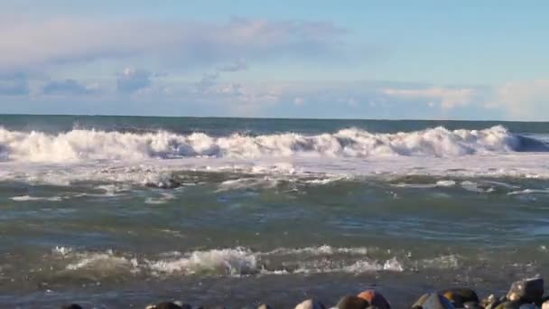Rocky shore on which large waves beat and bubble on the horizon line — Stock Video