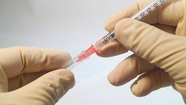 A tampa é removida da seringa de insulina com as mãos em luvas médicas — Vídeo de Stock