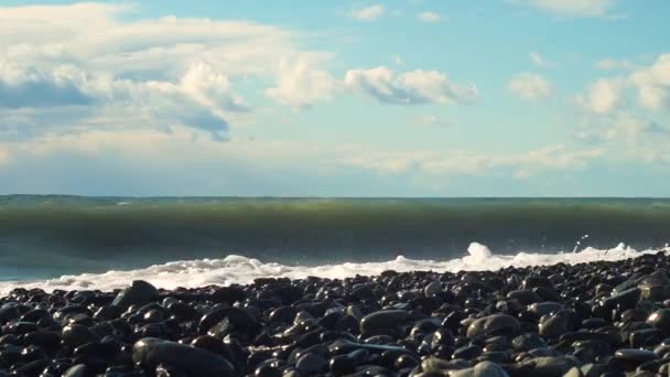 O spray da onda que veio para a costa e atingiu a praia rochosa. — Vídeo de Stock