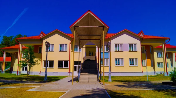 En separat byggnad med träd och en blå molnfri himmel på en solig dag — Stockfoto