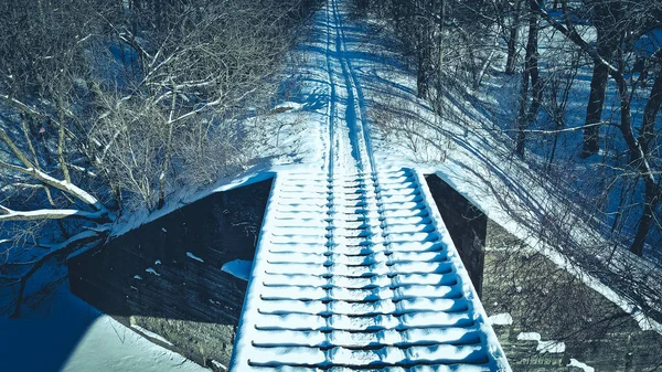 古い橋を渡るスノーモービルの線路は — ストック写真