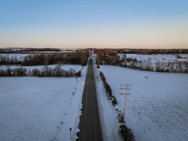 Vanishing point road with winter landscape in rural area.