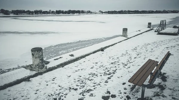 Lavička Dívá Ven Zamrzlé Řece Stopy Sněhu Dává Známky Toho — Stock fotografie