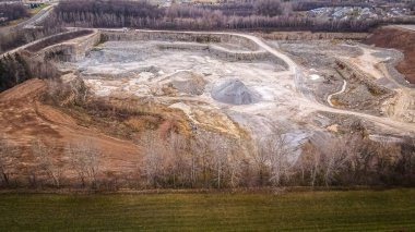 Taş yığınları ve tokmak yığınlarıyla açık çukur taşı ocağı.