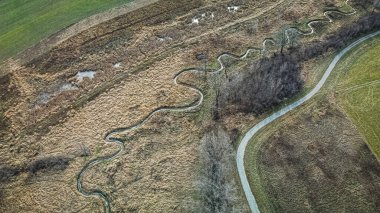 Bir iz, doğada dönen ve zikzak çizen bir dereyi takip eder..