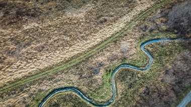 Bir iz, doğada dönen ve zikzak çizen bir dereyi takip eder..