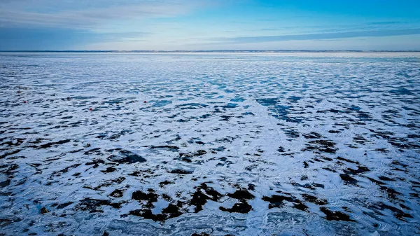 雪は部分的に凍った湖の表面を覆う 凍った表面で上記の風景の空 湖の反対側が見える — ストック写真