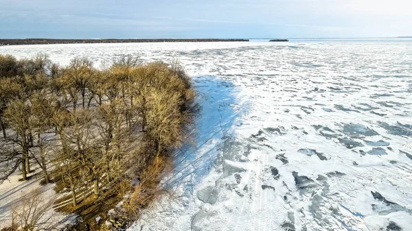 スノーモービルは凍った水を横断する 雪は湖の表面を覆い 上には青い空が見える — ストック写真