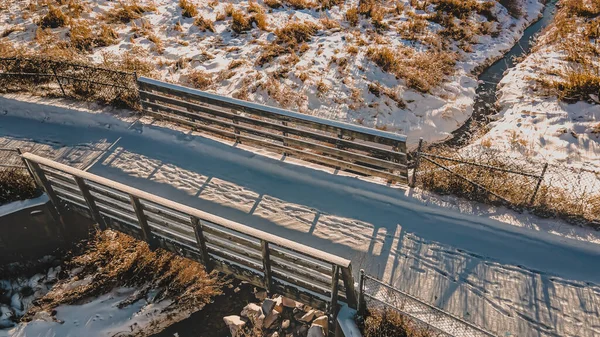 雪とトラックで冬の公共のウォーキングパス 太陽は影で大地を覆う — ストック写真