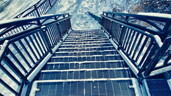 雪覆盖了城市的楼梯 通往上面的桥 — 图库照片