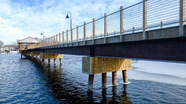 Kış mevsimi, bu yürüyen köprünün altındaki suyun bazı kısımlarını dondurdu..