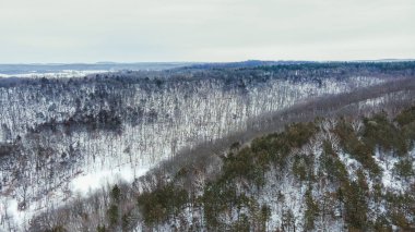 Sabahın erken saatlerinde, yuvarlanan tepeleri kaplayan kar manzarası.